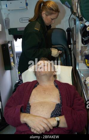 Medizintechniker, der sich darauf vorbereitet, Elektroden an der Brust eines älteren Mannes anzubringen Stockfoto