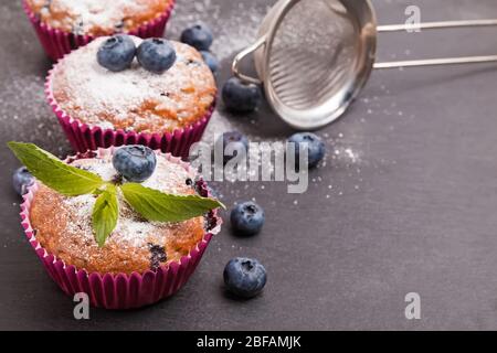 Leckere Heidelbeer-Muffins mit Puderzucker gepudert Stockfoto