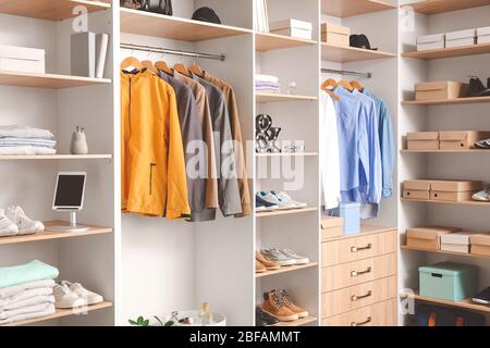 Moderne Garderobe mit stylischer Frühjahrskleidung und Accessoires Stockfoto