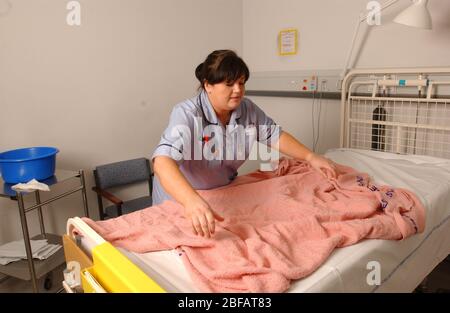 Die Krankenschwester macht ein Bett in einer Krankenhausabteilung. Stockfoto