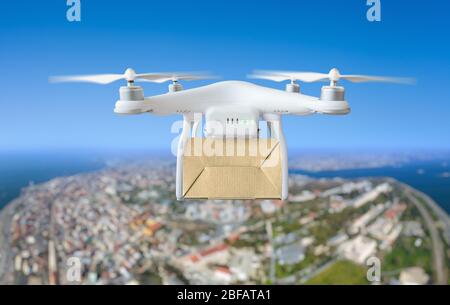 Technologische Sendung Innovation - Drohne schnelle Lieferung Konzept, Multicopter fliegen mit Karton über der Stadt Stockfoto