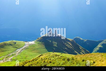 Gergeti christliche Kirche auf dem grünen Berg in der Nähe von Kazbegi, Stepancminda Dorf in Georgien, Kaukasus Stockfoto