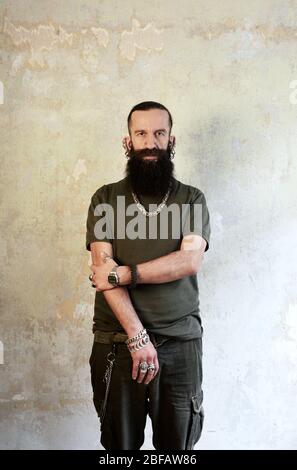 Männer mit Halskette und Piercing, die direkt in die Kamera schauen Stockfoto