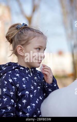 Nettes kleines Mädchen essen Zuckerwatte. Glückliche Kindheit und Kinder Emotionen Stockfoto