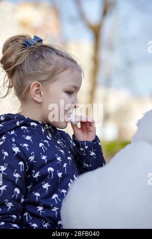 Nettes kleines Mädchen essen Zuckerwatte. Glückliche Kindheit und Kinder Emotionen Stockfoto