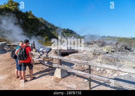 Ein Paar schaut sich den natürlichen Dampfventilkocher (He hangi ngawha) an, Te Puia, Te Whakarewarewa Geothermal Valley, Rotorua, Neuseeland Stockfoto