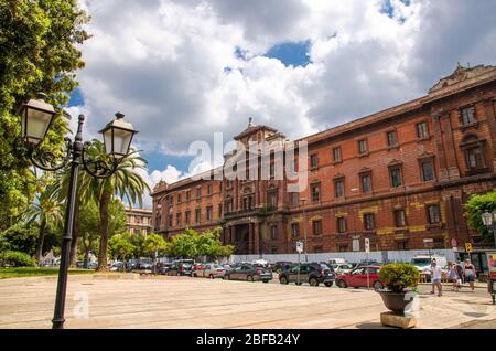 Taranto, Italien - 7. Mai 2018: Platz von Giardini Piazza Garibaldi und altes Gebäude, Straßenlaternen, Palmen vor dem blauen Himmel in historischen Zentrum Stockfoto