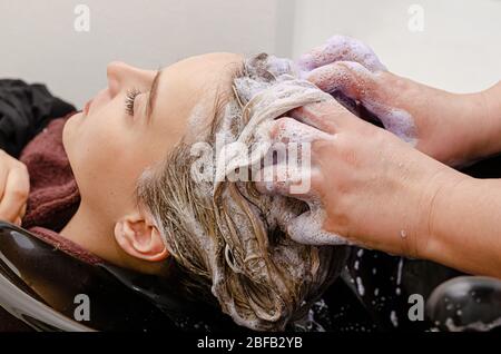 Haarstylisten, die nach dem Färben violettes Shampoo färben. Nahaufnahme. Stockfoto