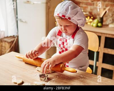 Der kleine Junge kocht in einer heimischen Küche. Glückliche Familie, glückliche Kinder Konzept. Stockfoto