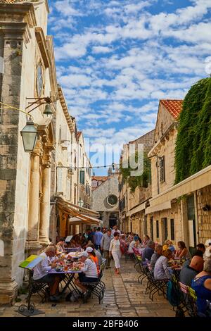 Die Menschen speisen draußen in einer Fußgängerzone in der Altstadt von Dubrovnik, Kroatien Stockfoto
