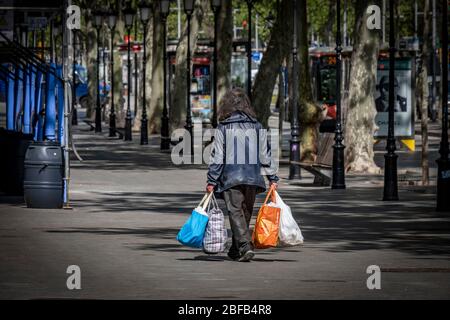 Ein Obdachloser, der während der Haft auf einer verlassenen Straße mit all seinen Habseligkeiten unterwegs ist.Barcelona überwindet einen Monat der Haushaft und der sozialen Distanz. Es ist bereits 34 Tage her, seit der 15. März, als die spanische Regierung einen Ausnahmezustand verordnete. Nur wesentliche Dienste funktionieren. Stockfoto