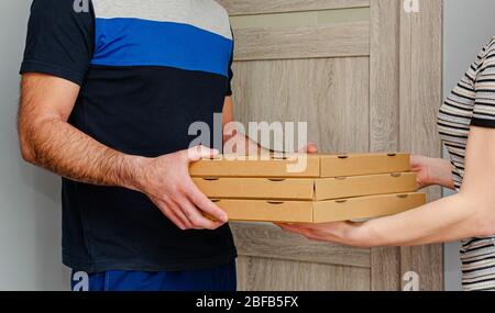 Mann, der Pizza an einen Kunden nach Hause liefert. Konzept für die Bestellung von Speisen. Stockfoto