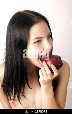 Eine junge Frau, die einen Apfel isst (Model veröffentlicht) Stockfoto