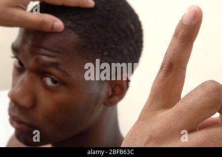 Ein Hausarzt führt den ‘Follow my Finger’ Eye Test an einem jungen männlichen Patienten durch, um die acht Gesichtsfelder – Muskeln, inferior, Superior, lateral, medi – zu überprüfen Stockfoto