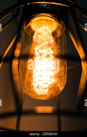 Vintage Glühbirne Edison in einer rustikalen Lampe Laterne Makro Stockfoto