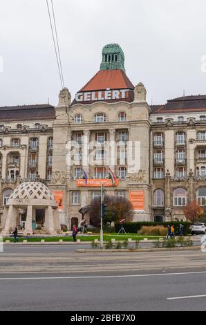 Budapest, Ungarn - 6. November 2019: Das berühmte Danubius Hotel Gellert in der ungarischen Hauptstadt. Jugendstil-Hotelgebäude mit angrenzender Straße und Straße. Bewölktes Tag, vertikales Foto. Stockfoto