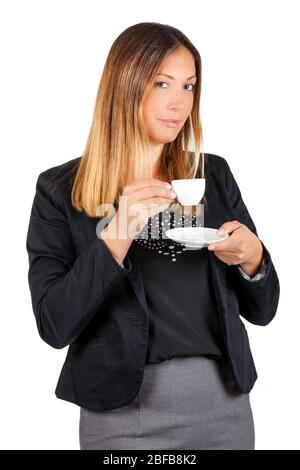 Geschäftsfrau, die Kaffee in der Tasse trinkt. Arbeitspause. Eine stehende Frau, die während ihrer Kaffeepause einen Kaffee getrunken hat. Die schöne junge Frau trinkt. Stockfoto