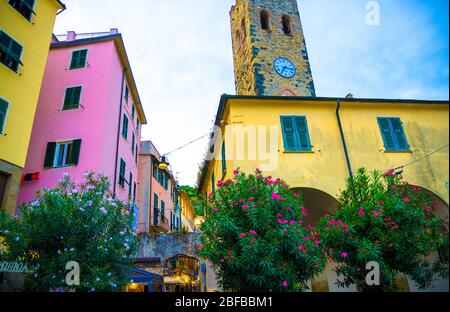 Katholische Kirche von San Giovanni Battista chiesa mit Uhrturm, bunten Gebäuden Häuser und Blumen rund um in Monterosso Dorf, Nationalpark CI Stockfoto