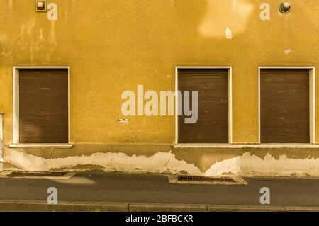 Alte Fassade mit 3 braunen Holzläden eines Hauses mit Bürgersteig Stockfoto