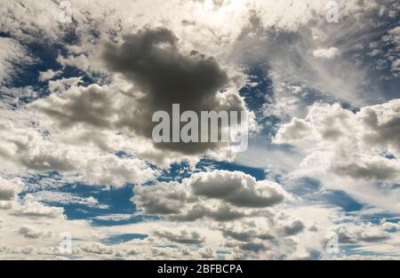 Dramatischer Wolkenhimmel mit dunklen Regenwolken und Sonne vor und nach Gewitter Stockfoto