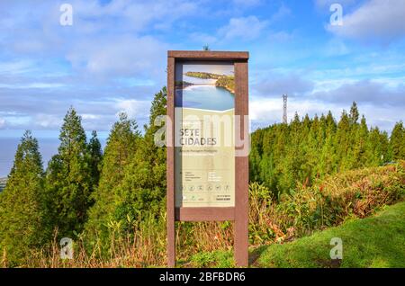 Sete Cidades, Azoren, Portugal - 12. Januar 2020: Informationsschild für Touristen in Sete Cidades. Hölzerne touristische Zeichen in portugiesischem Landschaftsschutzgebiet. Grüner Wald und Meer im Hintergrund. Stockfoto