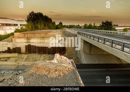 Baustelle Straßenbau und Brückenbau, Bau einer neuen Brücke und Abbau einer provisorischen Brücke im Sonnenuntergang Stockfoto