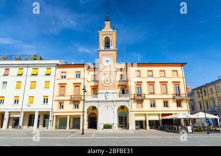 Traditionelles Gebäude mit Uhr und Glockenturm auf der Piazza Tre Martiri Platz der drei Märtyrer in der alten historischen touristischen Innenstadt Rimini mit blauem Himmel Stockfoto