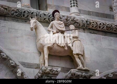 Der heilige Martin und der Bettler, ca. 1200, Statue an der Fassade der Kathedrale St. Martin in Lucca, Toskana, Italien Stockfoto