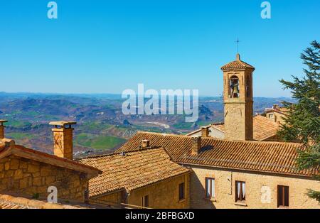 Alte Häuser mit Ziegeldächern und Glockenturm in San Marino - Landschaft Stockfoto