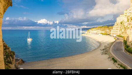 Tropea Stadt und Strand, Yacht-Boot im Tyrrhenischen Meer, bunte Gebäude auf hohen großen Felsen, Blick von der Wallfahrtskirche Santa Maria dell Isola Stockfoto