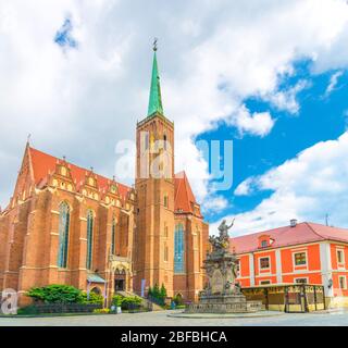 Collegiate Kirche des Heiligen Kreuzes und St. Bartholomäus katholische Kirche mit Backstein Turm Wand und Turm, Denkmal auf Kopfsteinpflaster Platz in alten historischen Stockfoto