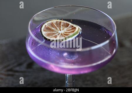 Lila Cocktail mit Limettenrad Stockfoto