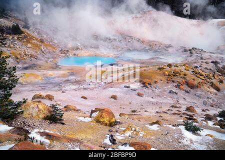 Dampf steigt aus dem türkisfarbenen Pool und den vielen geothermischen Eigenschaften, die in der Bumpass Hell im kalifornischen Lassen Volcanic National Park zu finden sind. Stockfoto