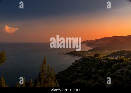 Die untergehende Sonne malt in den Hügeln vor der Küste der Halbinsel Gargano in der Region Apulien, Italien Stockfoto