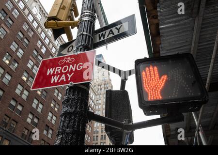 Straßenschilder mit falschen Weg, Fahrradroute, eine Richtung und ein rotes Stoppschild Hand in einem städtischen Gebiet. Stockfoto