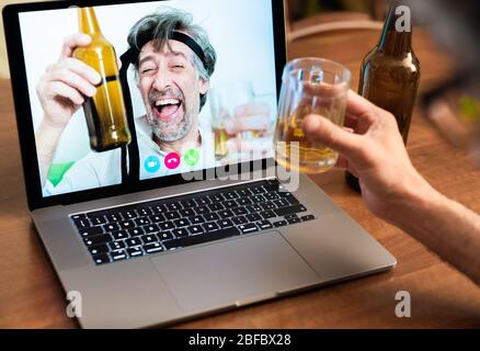 Arbeitskollegen feiern den Erfolg, indem sie sich bei Videoanrufen über Ferngespräche auf Bier betrinken, Freunde während eines Videoanrufs ihre Ellbogen heben Stockfoto