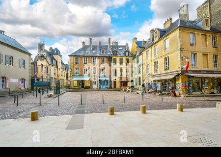 Der kleine Platz vor dem Eingang zur Kathedrale von Bayeux, mit bunten Geschäften und Cafés in der Normandie-Stadt Bayeux, Frankreich. Stockfoto