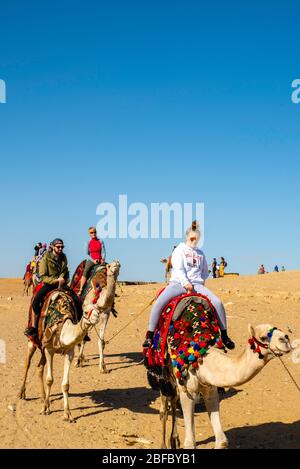 Eine Familie reitet Kamele im Gizeh Pyramid Complex, Gizeh, Ägypten. Stockfoto