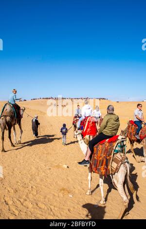 Eine Familie reitet Kamele im Gizeh Pyramid Complex, Gizeh, Ägypten. Stockfoto