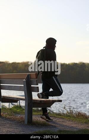 Haltern am See, Deutschland, Samstag 18 April 2020 Mann mit Rucksack allein auf dem Meer Covid-19 Drucke Stockfoto