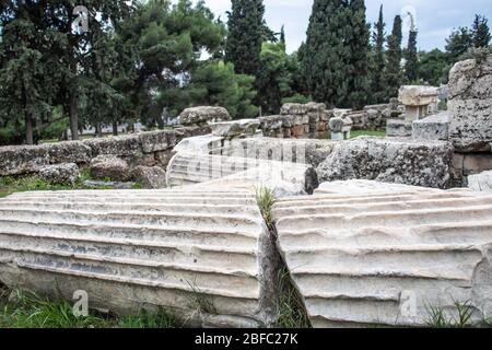 Eine zerbrochene Säule mit einem riesigen Riss, der in Athen auf dem Boden liegt. Alte Ruinen Stockfoto