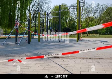 Rot-weißes Warnband mit Text 'Polizei' bedeutet Polizei in deutscher Sprache, umhüllt von geschlossenen Spielzeugen im Freien während der sozialen Distanz. Stockfoto
