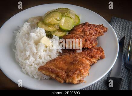 Ohne Knochen panierte Hähnchenbeine mit Dampf Reis und Gemüse auf der Seite. Stockfoto