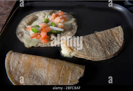 Quesadilla mit Pico de gallo oder Salsa bandera in einer Pfanne, ein traditioneller mexikanischer Snack Stockfoto