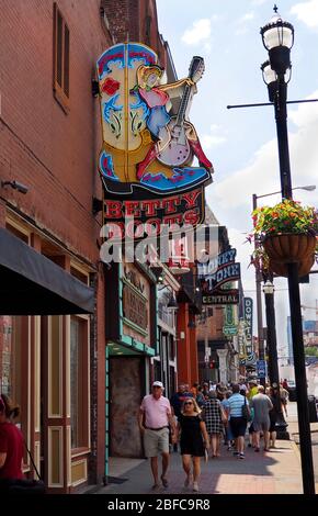 NASHVILLE, TENNESSEE - 25. JULI 2019: Touristen schlendern entlang Nashvilles Broadway unter bunten Neonschildern für Geschäfte und Saloons, includi Stockfoto