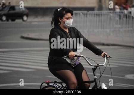 Mexiko-Stadt, Mexiko. April 2020. MEXIKO-STADT, MEXIKO-APRIL 15: Eine Frau, die eine chirurgische Maske als Schutzmaßnahme trägt, fährt mit dem Fahrrad inmitten des täglichen Lebens der Coronavirus-Sperre. Die mexikanische Regierung machte es für jeden, der eine Schutzmaske trägt, einmal außerhalb seiner Häuser obligatorisch, einen Versuch, die Ausbreitung der Covid-19 einzudämmen. Am 15. April 2020 in Mexiko-Stadt, Mexiko (Foto: Eyepix Group/Pacific Press/Sipa USA) Quelle: SIPA USA/Alamy Live News Stockfoto