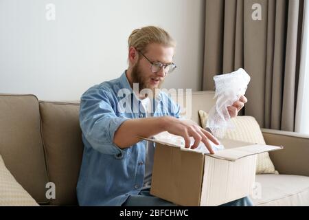 Happy man Kunde öffnen Karton Auspacken Post-Mail-Lieferpaket. Stockfoto