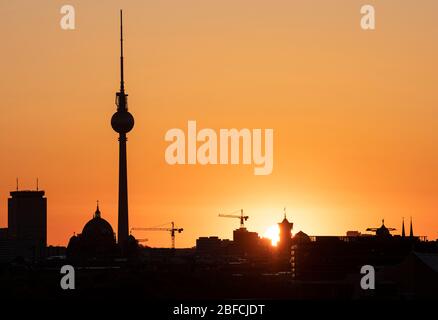 Berlin, Deutschland. April 2020. Die Sonne geht am frühen Morgen hinter dem Fernsehturm und dem Roten Rathaus auf. Quelle: Fabian Sommer/dpa/Alamy Live News Stockfoto