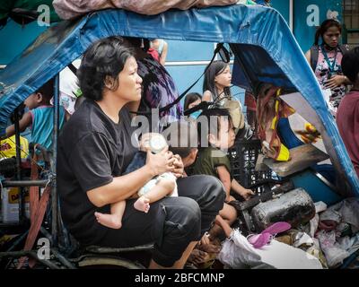 Capital District, Philippinen. April 2020. (Anmerkung für die Redaktion: Bild, das mit einem Mobilgerät aufgenommen wurde.) Eine Mutter sah, wie die Flasche ein Kind fütterte, als Feuer durch das „Happyland“, ein Slumgebiet in Manila, am Samstag, Barangay 105, Zone 9, Bezirk 1, fegte und sich schnell ausbreitete, was das Büro für Brandschutz veranlasste, die Task Force Alpha oder einen mittleren Alarm auszulösen. (Foto von Rick Mupas/Pacific Press) Quelle: Pacific Press Agency/Alamy Live News Stockfoto