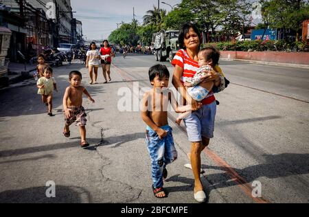 Capital District, Philippinen. April 2020. (Anmerkung der Redaktion: Bild aufgenommen mit einem mobilen Gerät.) Frau sah ein Kind tragen, als das Feuer durch „Happyland“, ein Slumgebiet in Manila am Samstag, Barangay 105, Zone 9, Bezirk 1, fegte und sich schnell ausbreitete, was das Büro für Brandschutz veranlasste, die Task Force Alpha oder einen mittleren Alarm zu auslösen. (Foto von Rick Mupas/Pacific Press) Quelle: Pacific Press Agency/Alamy Live News Stockfoto